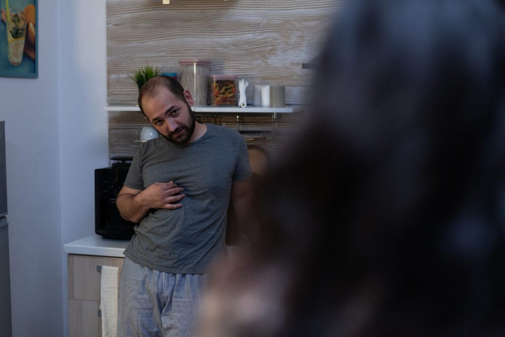Homem solteiro ajustando seu dispositivo de vigilância residencial em um apartamento moderno.