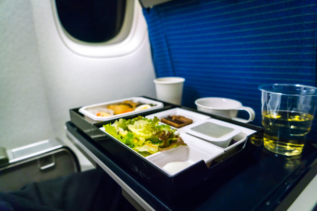 Uma pessoa feliz mostrando sua marmita segura para levar alimentos no avião em sua bagagem de mão.