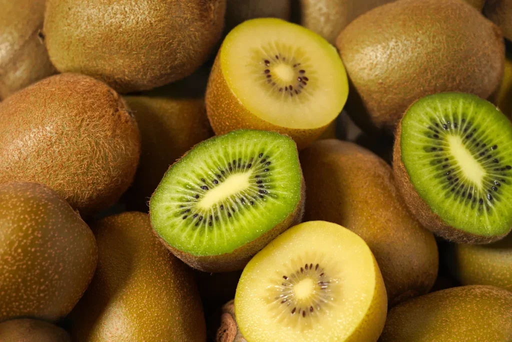 Uma pessoa segurando um kiwi com casca para ilustrar os benefícios da casca do kiwi para a saúde