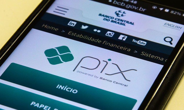 Uma pessoa segurando um smartphone com a tela exibindo a opção de criar QR code do Pix para facilitar pagamentos