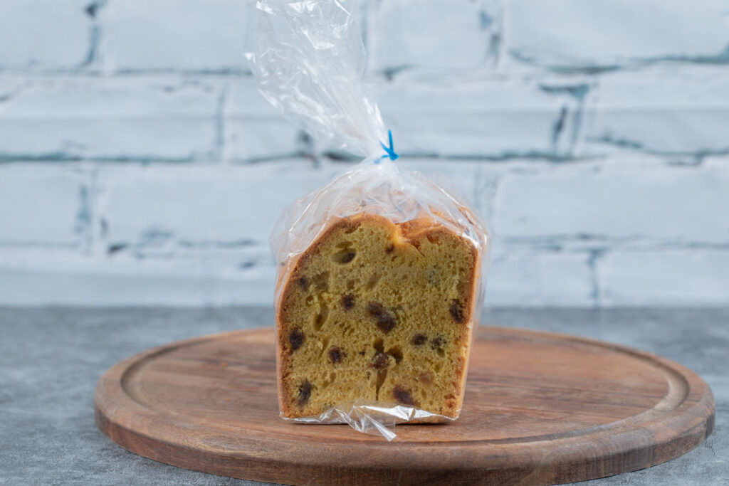 Mulher feliz escolhendo o pão mais saudável no mercado, lendo o rótulo com atenção.
