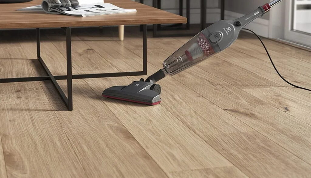 Mulher limpando o filtro de um aspirador vertical, resolvendo por que o aspirador vertical perde potência.