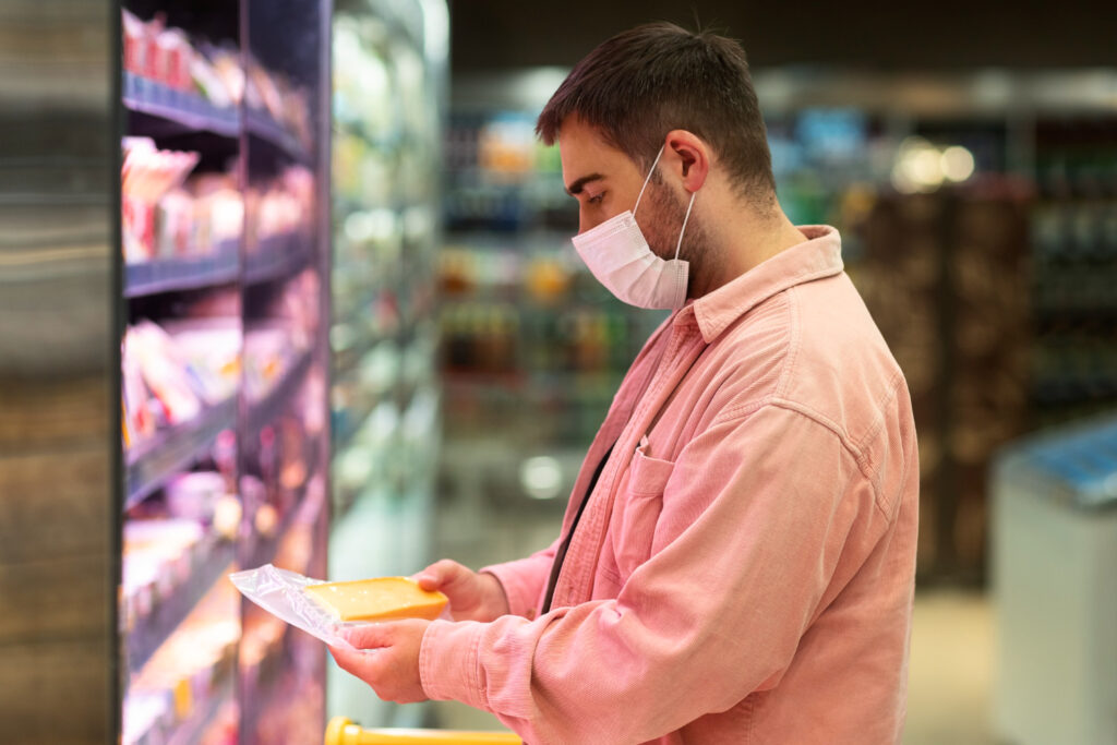 Pedaço de queijo parmesão sendo embalado em papel manteiga para manter o queijo fresco
