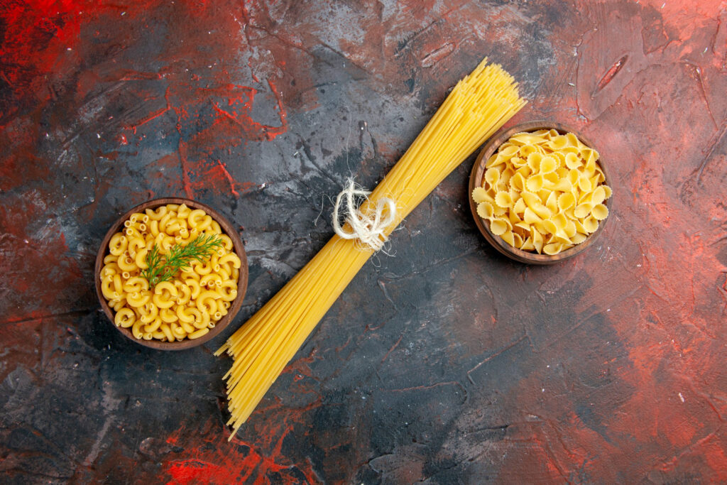 Close-up de um pegador de macarrão de inox em uma bancada de cozinha, ilustrando um utensílio barato e versátil