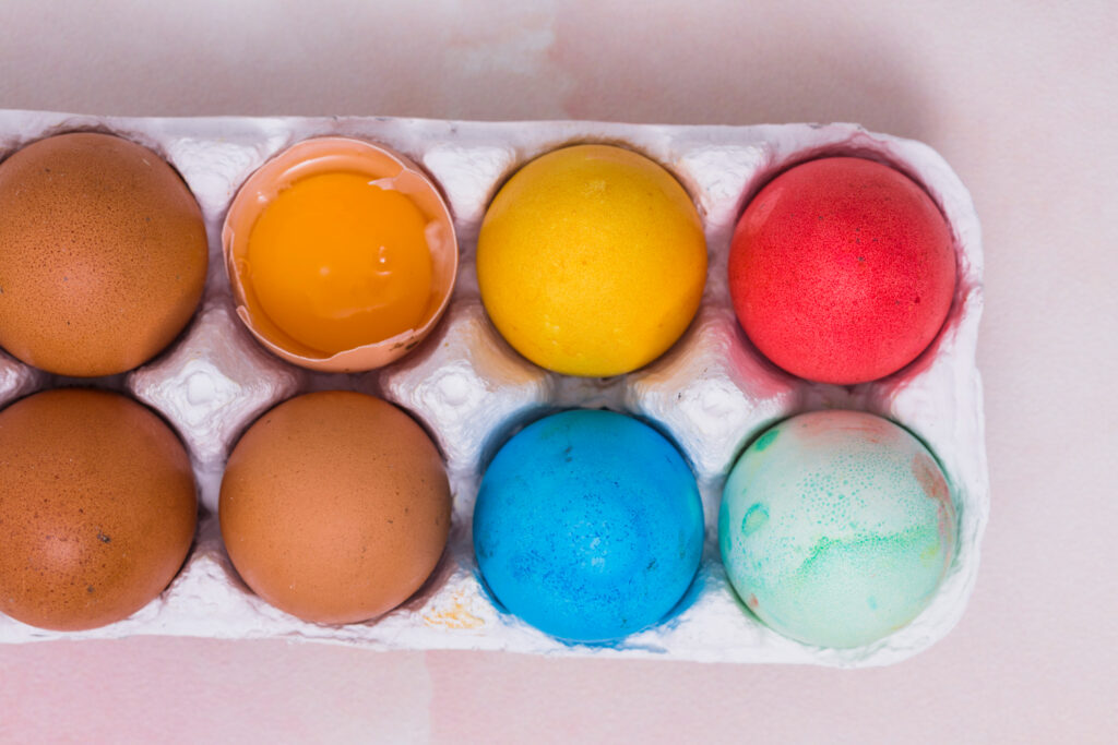 pessoa quebrando um ovo fresco em uma tigela, destacando a gema e a clara, um sinal de qualidade do ovo.