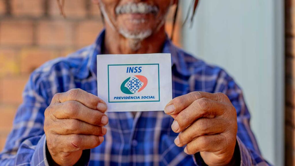 Mulher sorridente lendo documentos sobre as regras da aposentadoria integral no Brasil