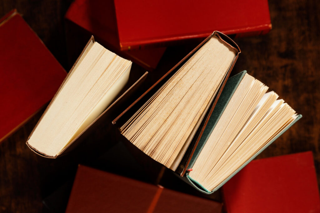 Pilha de livros antigos com manchas escuras, um claro sinal de mofo nos livros e documentos.