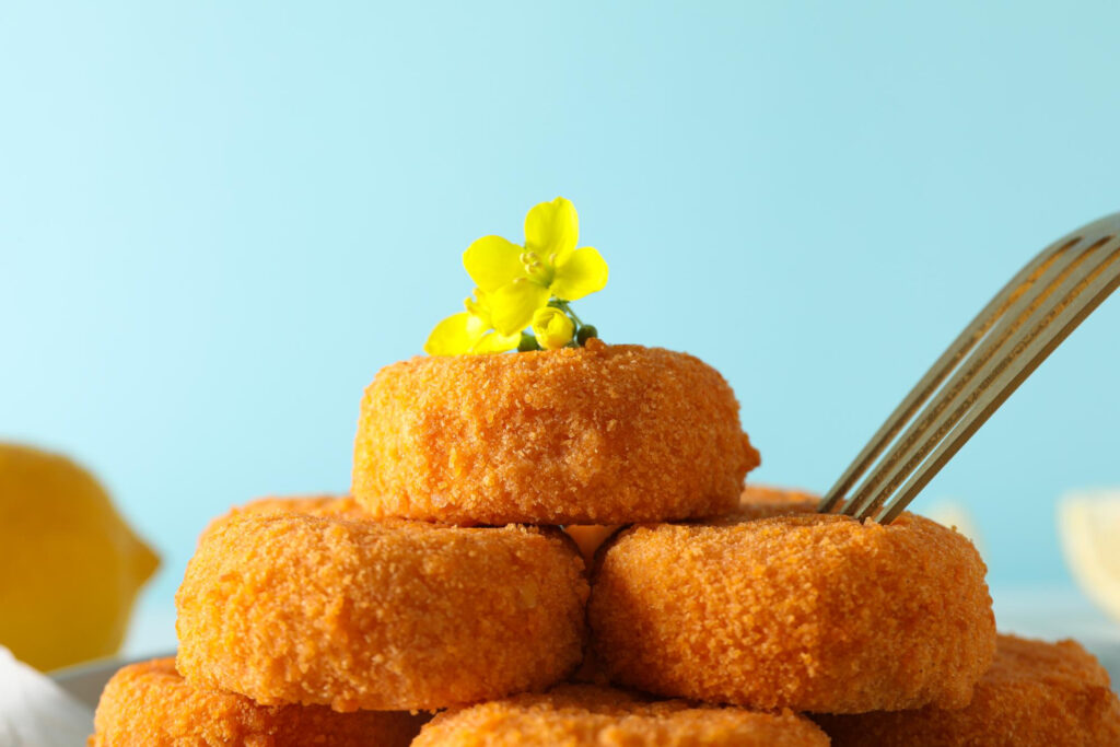 Bolinhos de bacalhau dourados numa travessa. O segredo para que a fritura não fique oleosa.