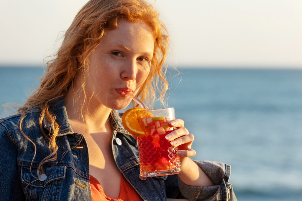 Copo de liquidificador com frutas e gelo ao lado, ilustrando o uso do liquidificador nas férias.